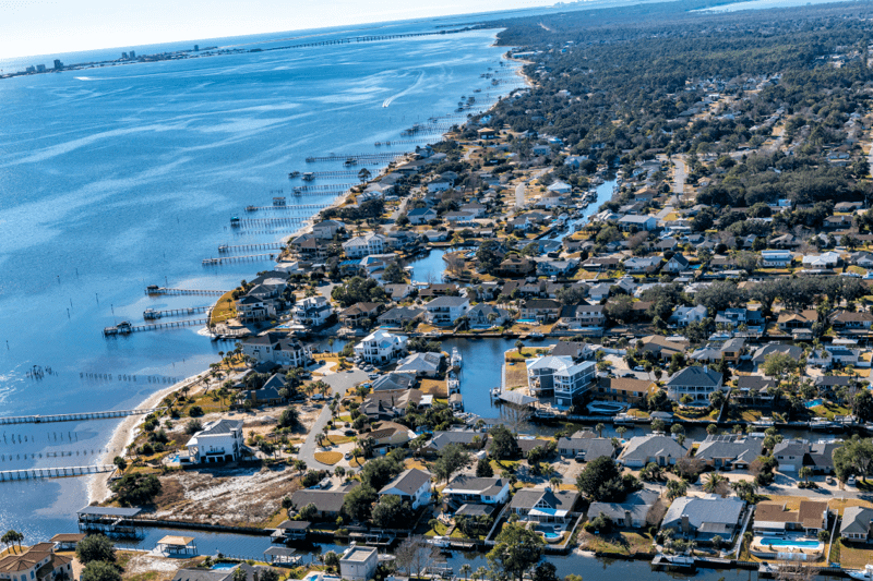 Aerial view of Gulf Breeze waterfront homes and docks near Pensacola Bay.