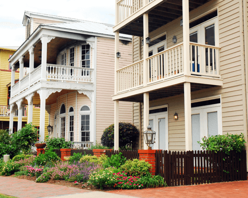 Charming historic-style homes with front porches and gardens in Pensacola, showcasing architectural beauty for those looking to buy a home in Pensacola.